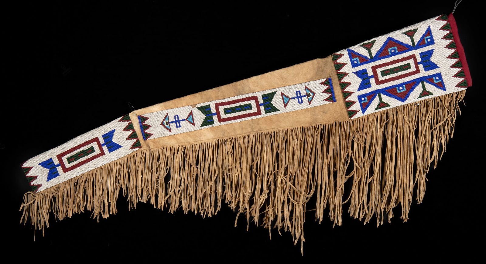 Native American Plains Tribe Beaded Leather Rifle Bag: North America, Western United States, Great Plains region, ca. early to mid-20th century CE. A rifle bag constructed in supple tan leather with a long fringe edge and bold, carefully laid beadwork pan