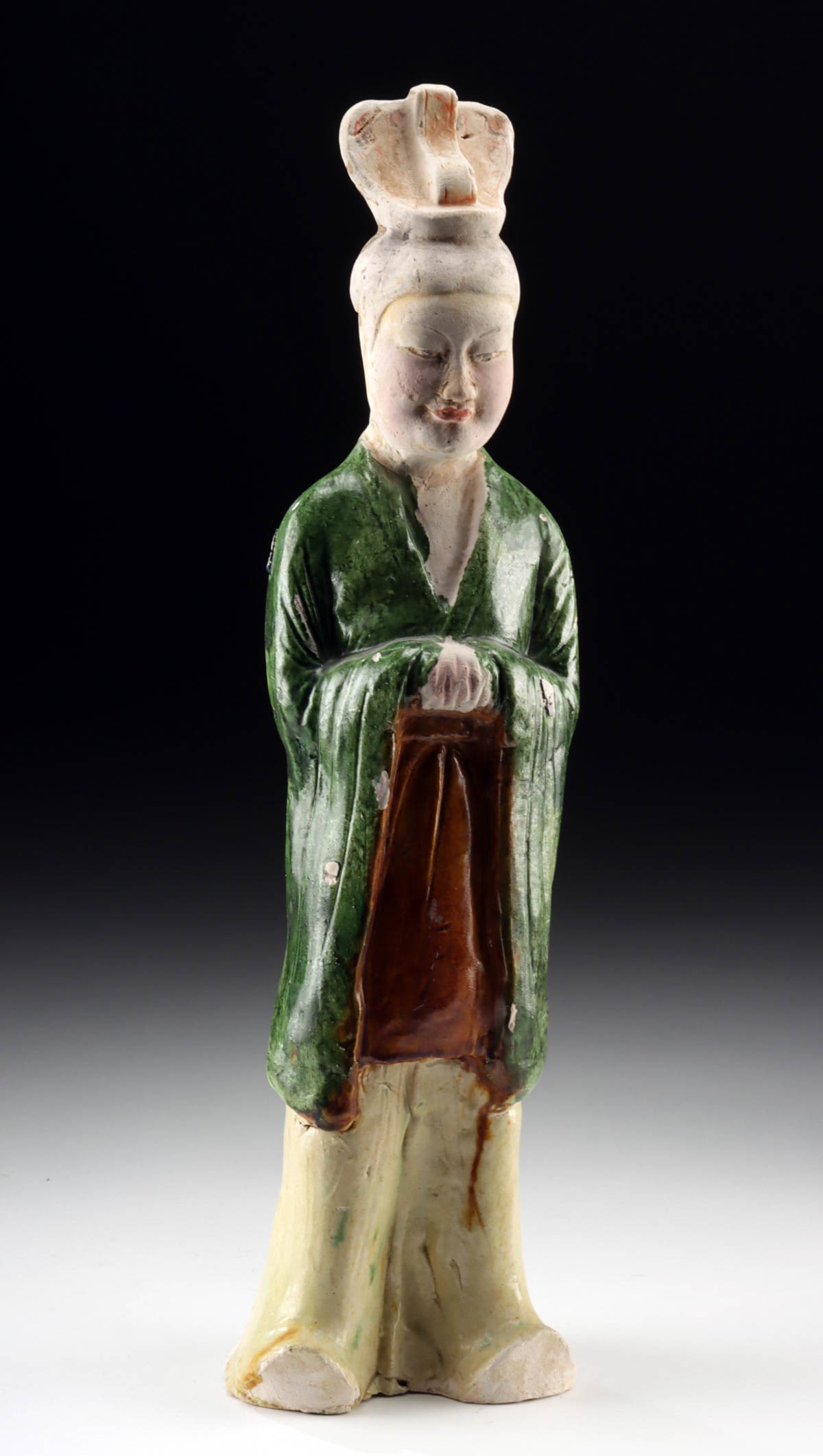 Tang Dynasty Sancai Glazed Attendant in Flowing Robes (TL'd): East Asia, China, Tang Dynasty, ca. 618 to 907 CE. A finely modeled sancai-glazed pottery mingqi figure, its form distinguished by graceful posture and serene expression. The figure stands with hands