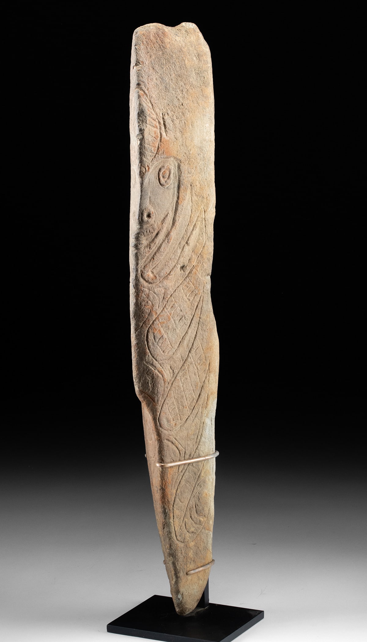 Tall Papua New Guinea Stone Stele - Stylized Visage & Interlocking Motifs: Oceania, Papua New Guinea, ca. 20th century CE. A tall stone figure rises with a quiet, commanding presence, its carved face emerging from the surface as if listening for the echo of old songs. The ma