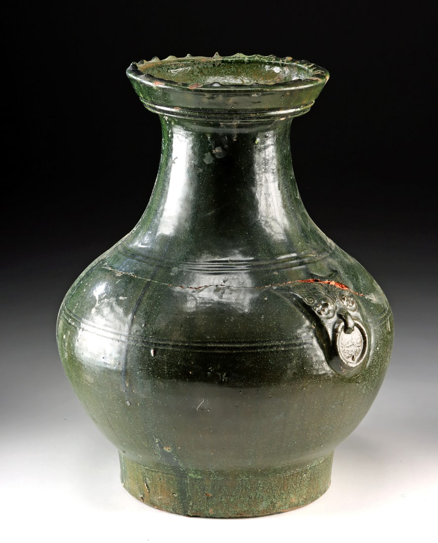 Large Chinese Han Dynasty Glazed Jar w/ Taotie Masks: East Asia, China, Han Dynasty, ca. 206 BCE to 220 CE. A commanding Han dynasty pottery jar whose swelling silhouette and deep green glaze give it both sculptural presence and quiet authority. The vess