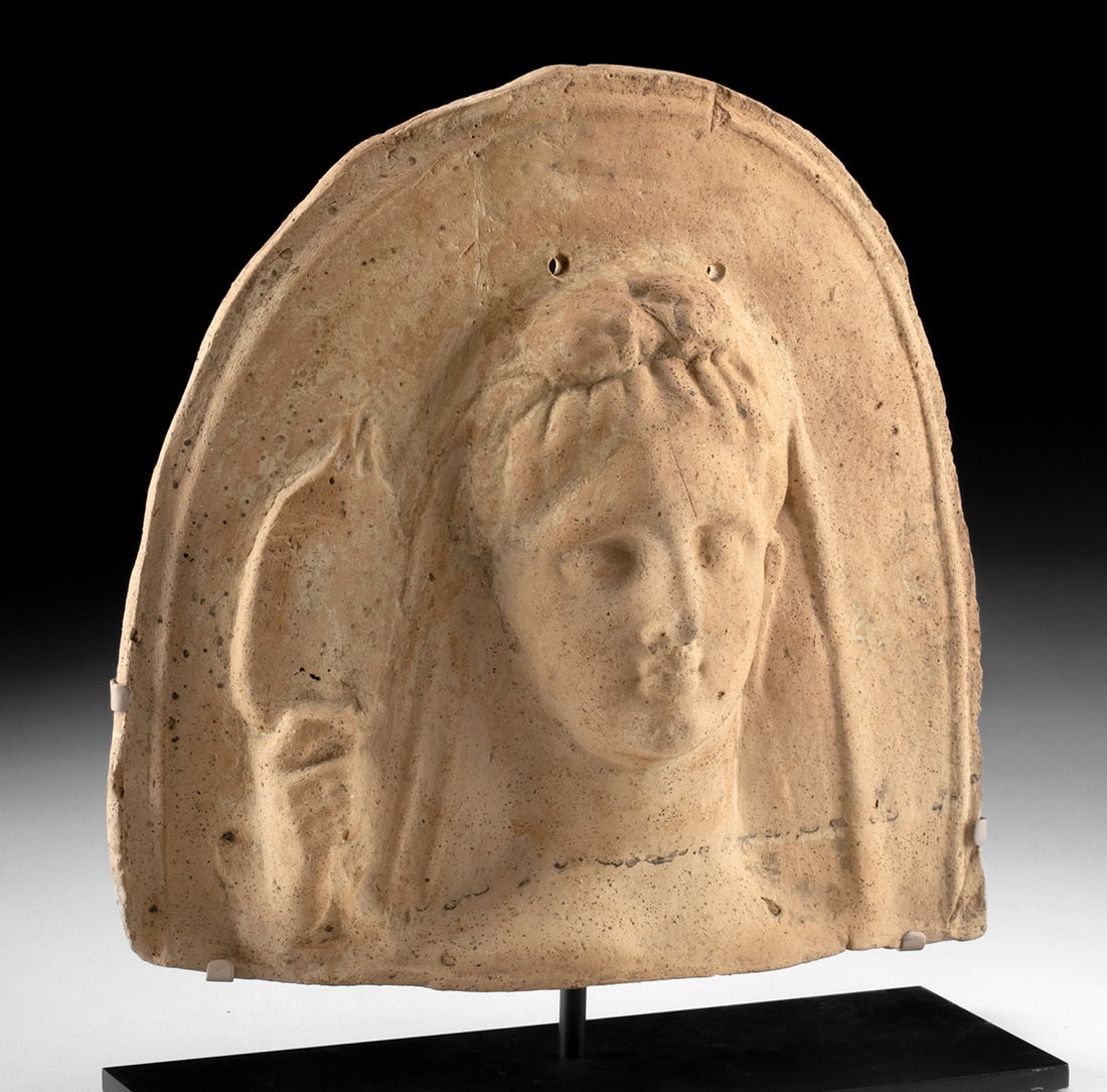 Tarentum Votive Bust Woman Holding Pomegranate: South Italic, Magna Graecia, Tarentum, ca. late 4th century BCE. A mold-formed terracotta votive bust of delicate form featuring a stylized woman, perhaps the goddess Turna. The dignified figure is dr
