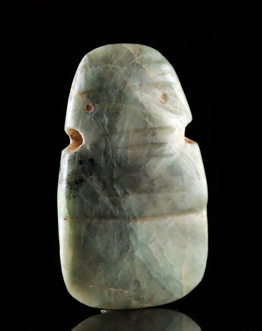 Costa Rican Greenstone Avian Figural Pendant: Pre-Columbian, Central America, Costa Rica, ca. 700 to 900 CE. A Costa Rican greenstone figural pendant carved in an abstract avian form distills bird imagery into a powerful, pared-down silhouette. T