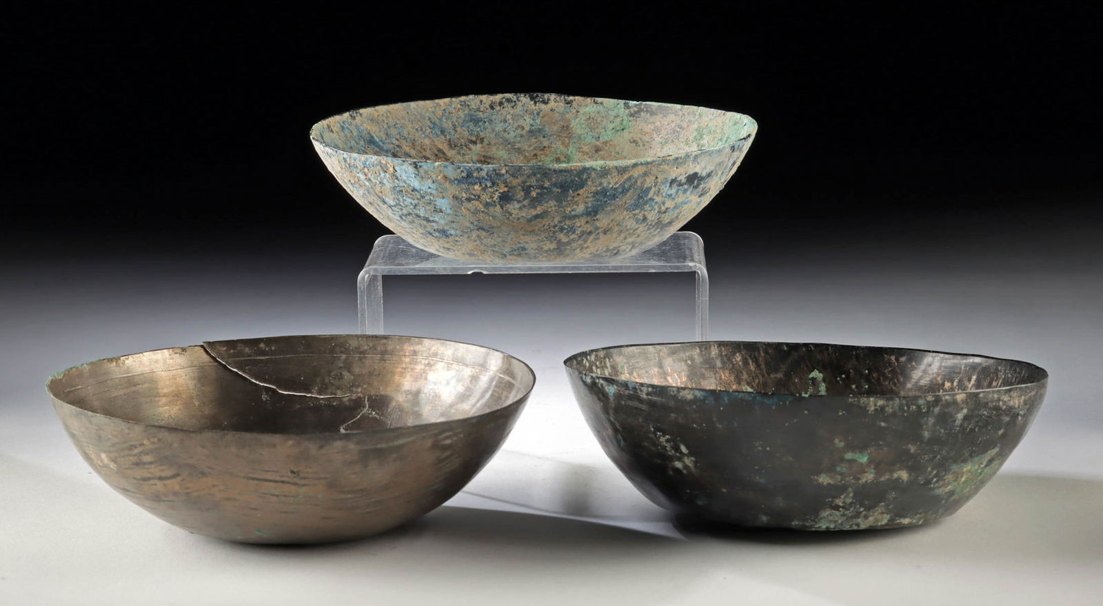 Three Ancient Sassanian Persian High Tin Bronze Bowls: Near East / Central Asia, Persia, Sassanian Empire, ca. 3rd to 7th century CE. Three bronze bowls hammered from thin metal sheets with concentric circles etched across the interior surfaces. They reta