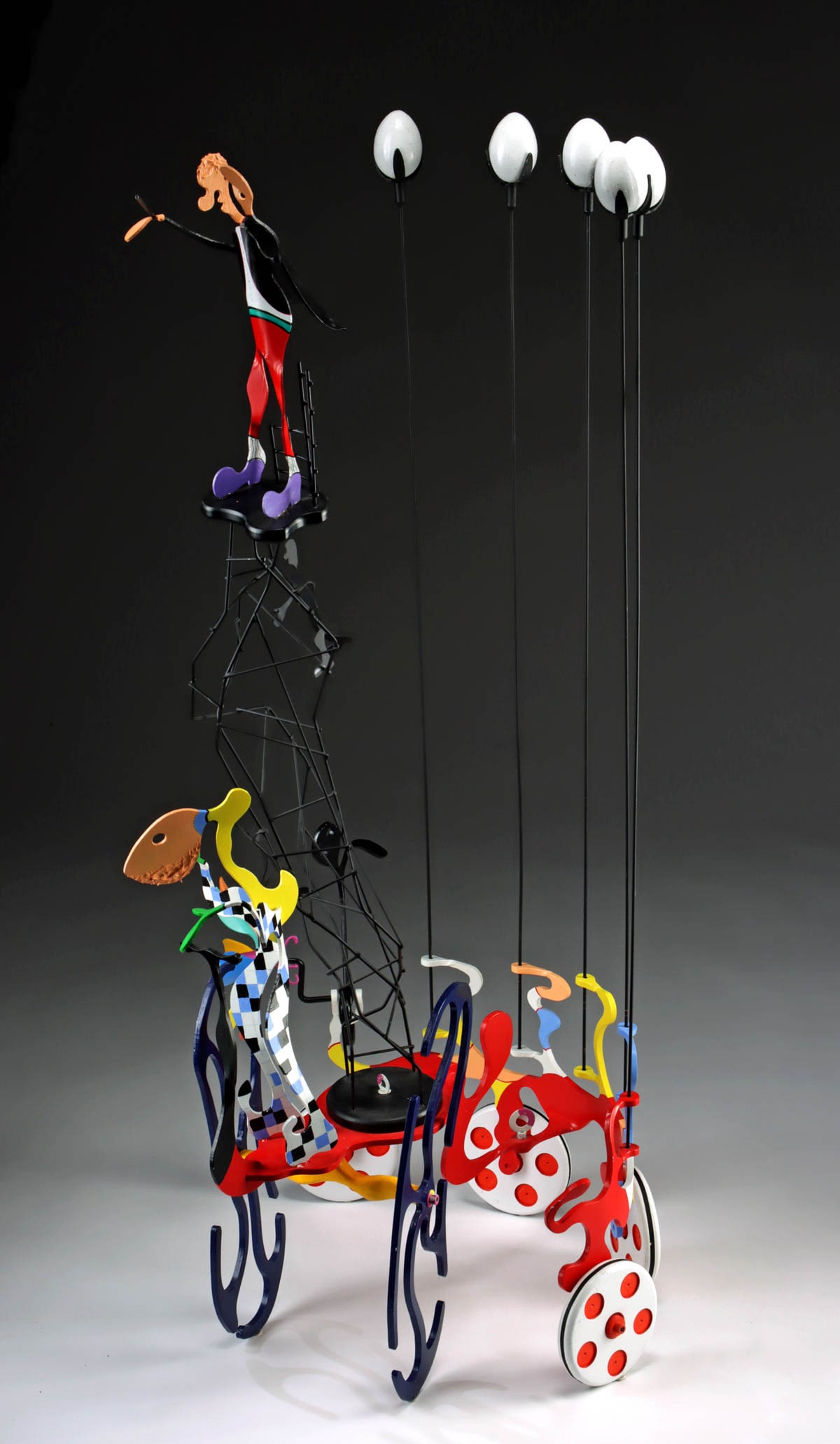 Don Mitchell Sculpture "Symphony in Egg Minor" (2002): Don Mitchell (American, 1938-2025). "Symphony in Egg Minor" mixed media (aluminum, wood, acrylic paint, and paper mache) sculpture, 2002. Signed and dated on red section above one wheel. A unique scul