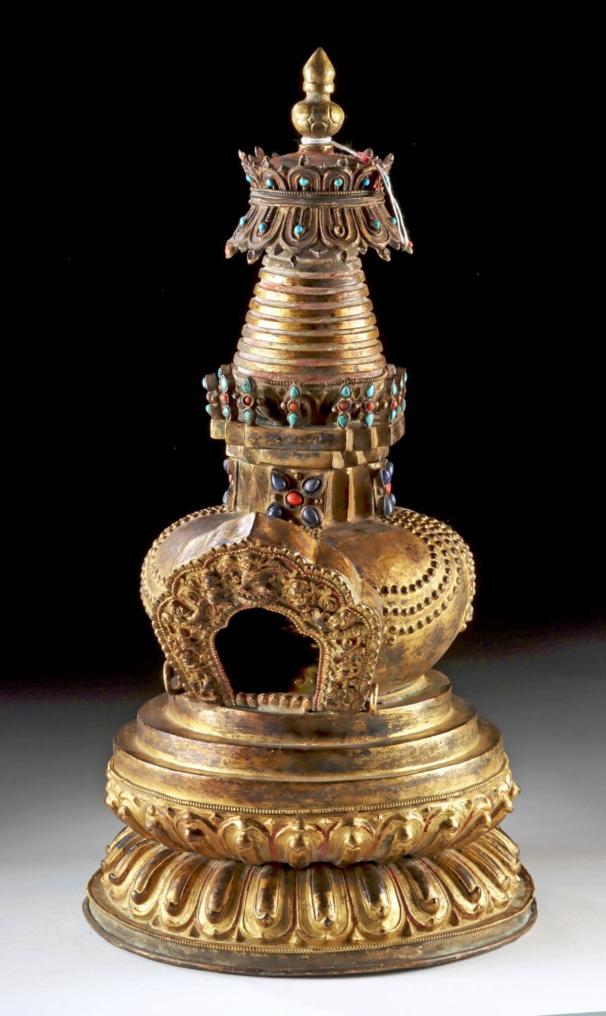 Buddhist Gilt Copper Chaitya Stupa w/ Amitayus Buddha: Central Asia, Nepal / Tibet, ca. 19th century CE. A magnificent gold washed-copper votive shikharakuta chaitya (small temple-stupa) statue of ornate, multi-tiered form, the domed base rising from a lo