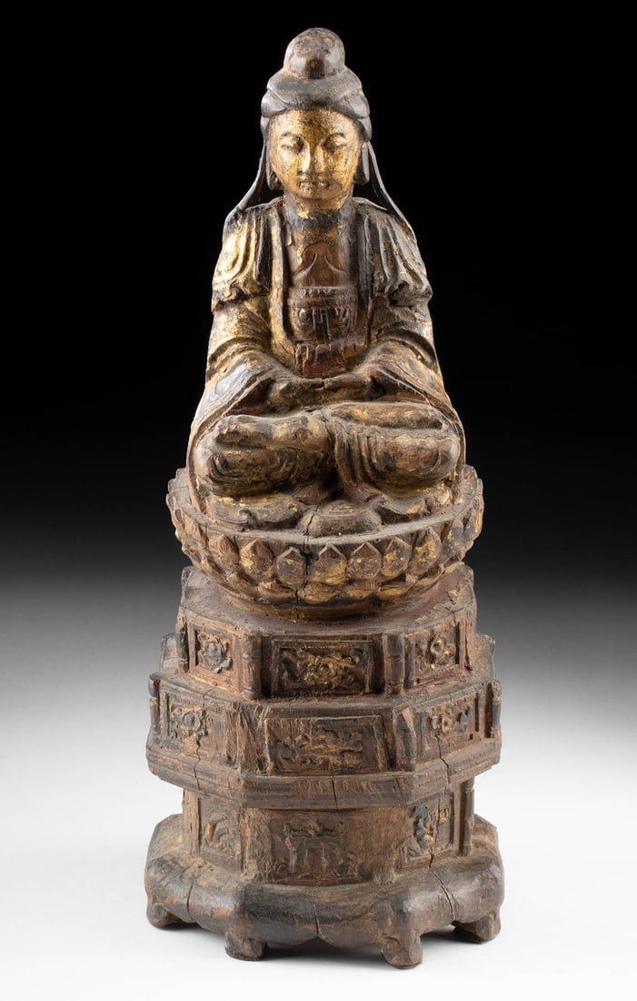 Chinese Ming Dynasty Gilt Wood Seated Guanyin: East Asia, China, Ming Dynasty,. Ca. 1368 to 1644 CE. A splendid wooden sculpture of the bodhisattva Guanyin seated in dhyanasana atop a lotus throne and tri-tiered pedestal. Draped in a long, cascadi