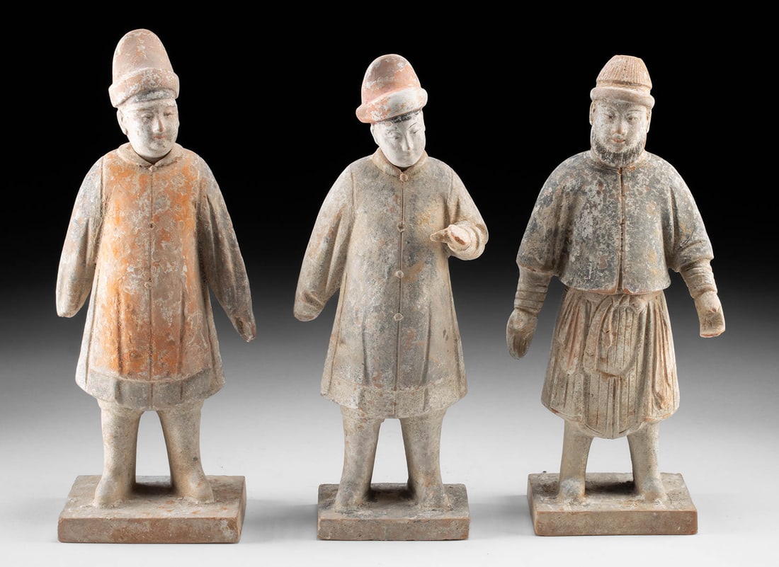 Three Chinese Ming Dynasty Pottery Attendant Figures: East Asia, China, Ming Dynasty, ca. 1368 to 1644 CE. A group of three Ming Dynasty pottery attendant figures, each shaped with the poised stillness expected of tomb guardians crafted to accompany the