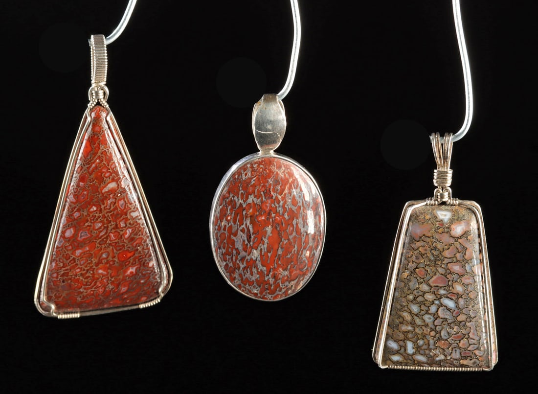 Three Dinosaur Bone Fossil Pendants in Silver Settings: North America, Western United States, Mesozoic era, ca. 252 to 66 million years ago. A striking group of three pendants fashioned from fossilized dinosaur bone, each cut and polished to reveal the ext