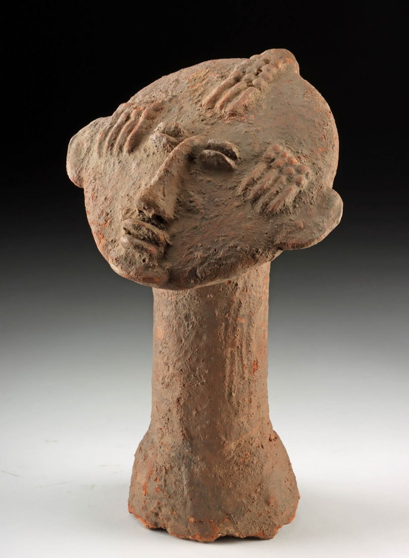 Ancient West African Bura Pottery Funerary Head: West Africa, Niger/Burkina Faso, Bura-Asinda-Sikka culture, ca. 3rd to 10th century CE. A pottery head with an elongated cylindrical neck and a broad, disk-like face modeled in a strongly stylized man