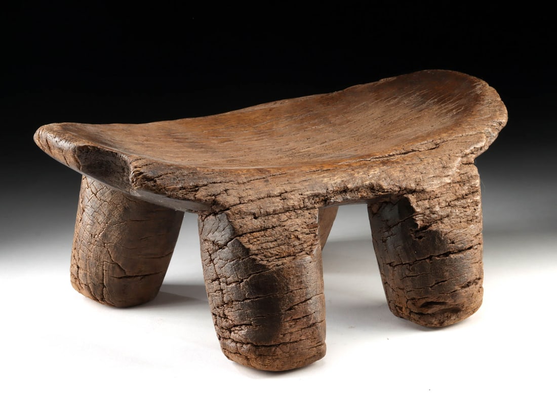 Early African Lobi Wooden 4-Legged Stool: West Africa, Burkina Faso, Lobi Culture, ca. 19th to early 20th century CE. A traditional Lobi wooden woman's stool, hand-carved from a single block of dense wood. The stool features four sturdy cylin