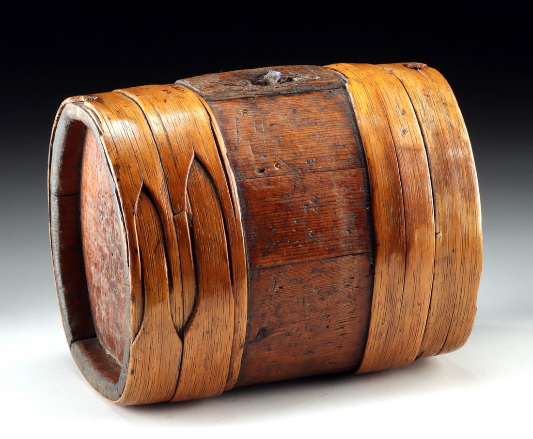 European 18th C. Wooden Barrel Costrel Canteen Vessel: Europe, ca. 18th to 19th century CE. A wooden costrel or canteen formed as a compact barrel-like vessel bound by broad, bent wooden bands around a darker staved body. A round mouth opening is bored th