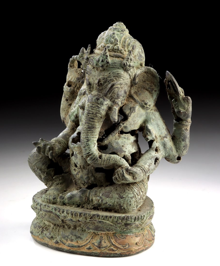 Indonesian Hindu God Ganesha Brass Sculpture: Southeast Asia, Indonesia, Bali, ca. late 19th to early 20th century CE. A cast brass sculpture depicting the elephant-headed deity Ganesha seated in a yogic posture upon a lotus base. The figure is r