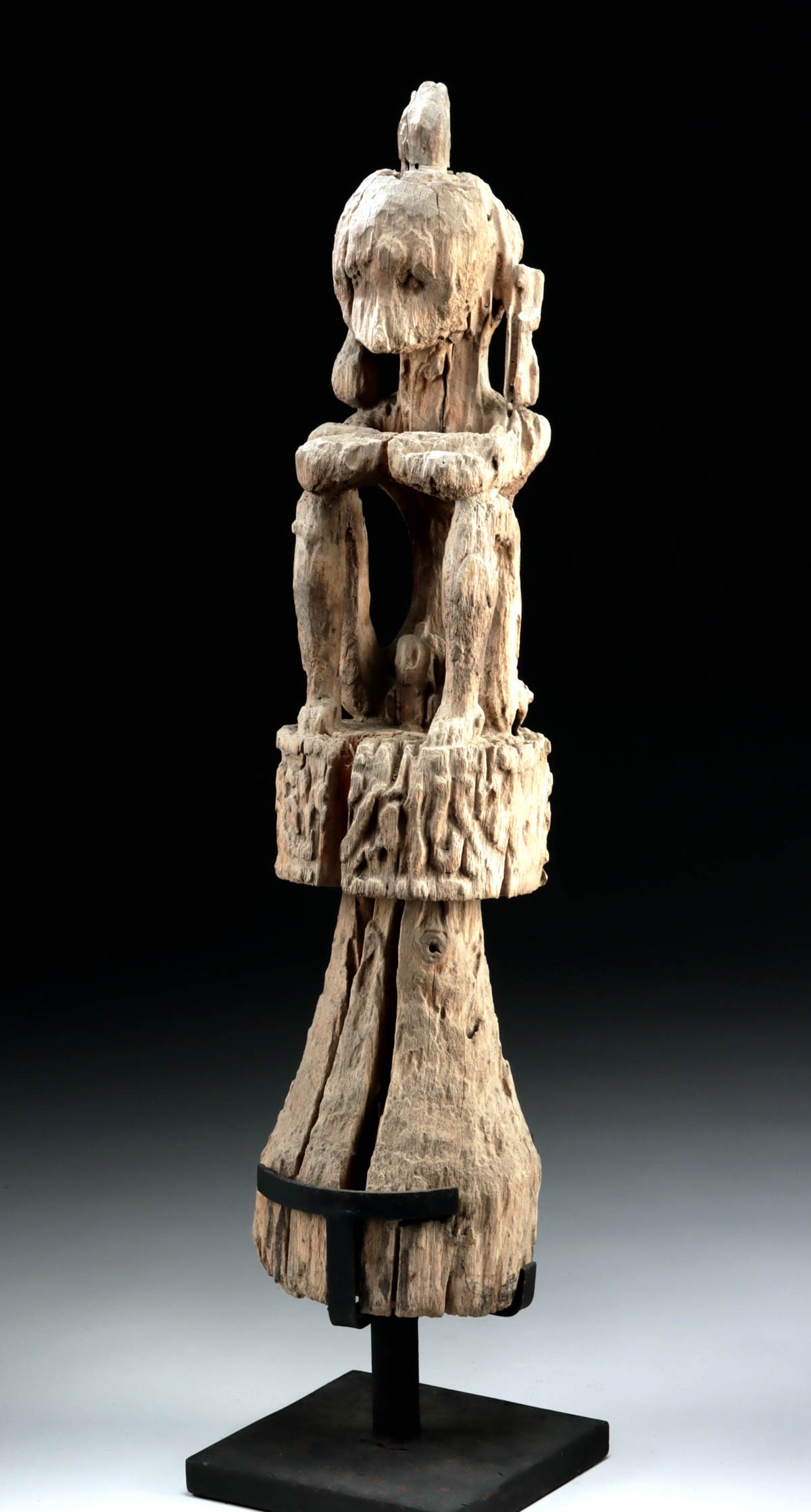 Dayak Hampatong Seated Guardian Figure Wooden Sculpture: Southeast Asia, Indonesia, Borneo, Dayak culture, ca. 19th century CE. A seated ancestral guardian figure (hampatong) carved with an oversized head and bent arms resting across raised knees, presented