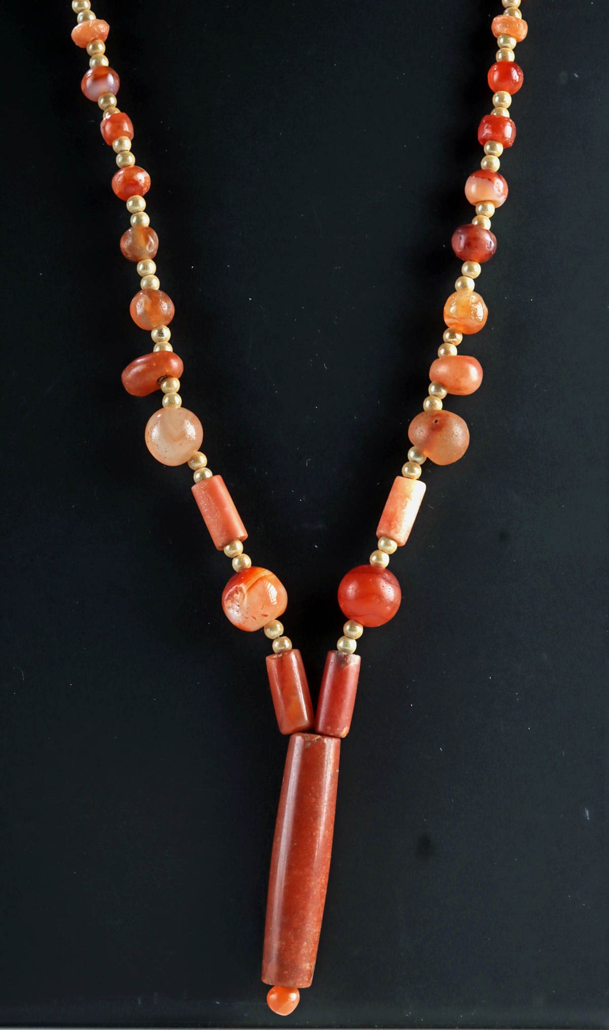 Wearable Ancient Carnelian & Agate Beaded Necklace: Roman Empire, Egyptian, Near Eastern, and Central Asian regions, ca. 1000 BCE to 1000 CE. A vibrant strand of ancient stone beads in warm orange and creamy white tones, including semi-opaque banded ag