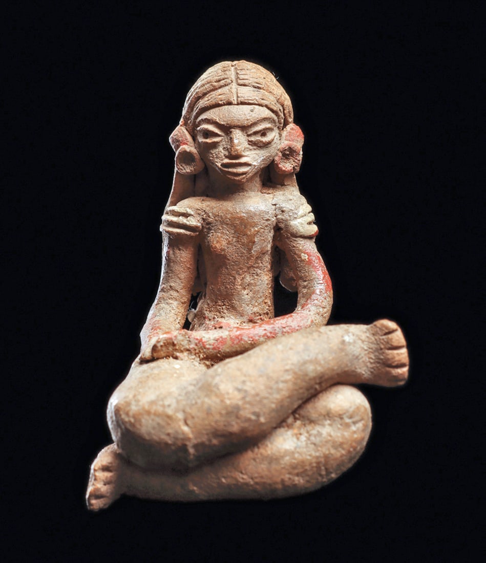 Xalitla Seated Female with Long Hair: Buff color solid pottery seated female figure with legs crossed, resting both hands on her right leg. Depicted with a fancy incised detailed long hairdo. Wearing a belt type loincloth , small ear spoo