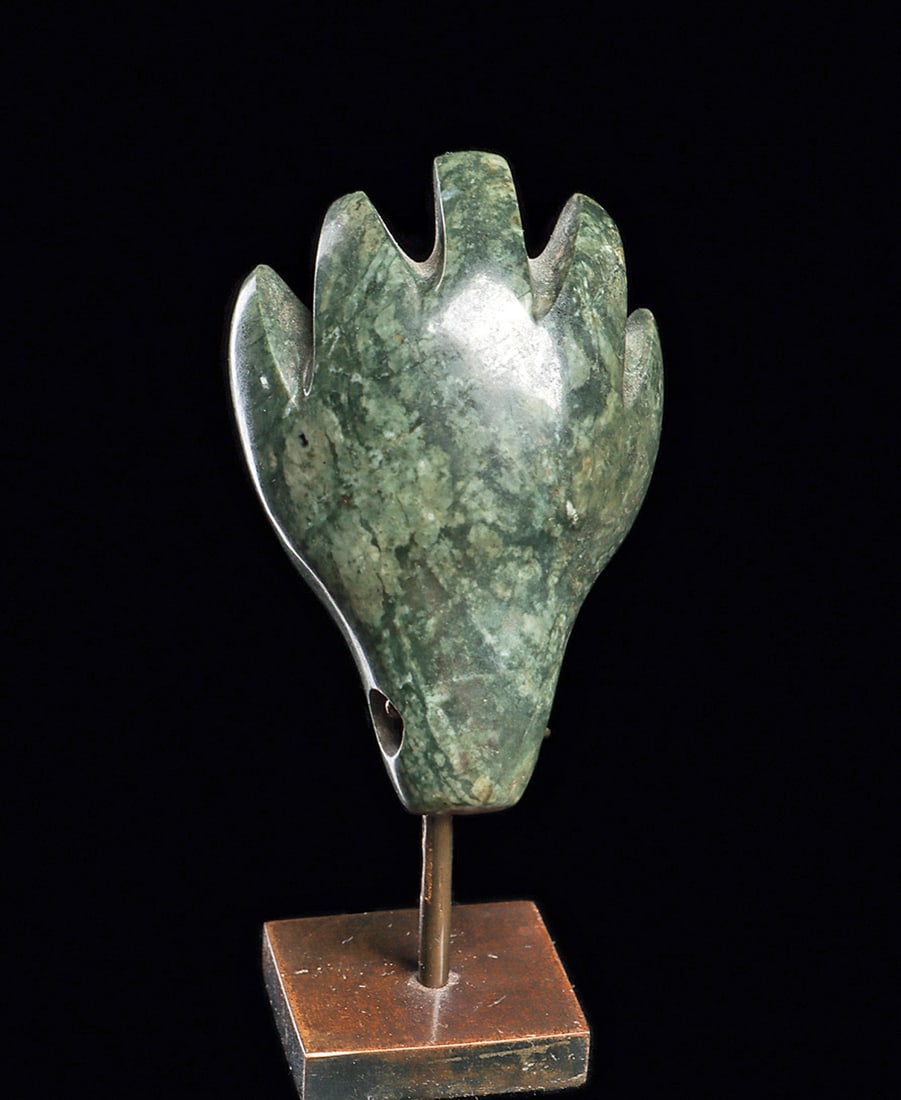 Olmecoid Jade Hand Pendant: Carved blue-green jade pendant depicting a stylized human hand. Has wide separated fingers, a scooped palm, tapering to a tapered wrist, with a biconical drilled suspension hole. Intact, exc. cond. Cu