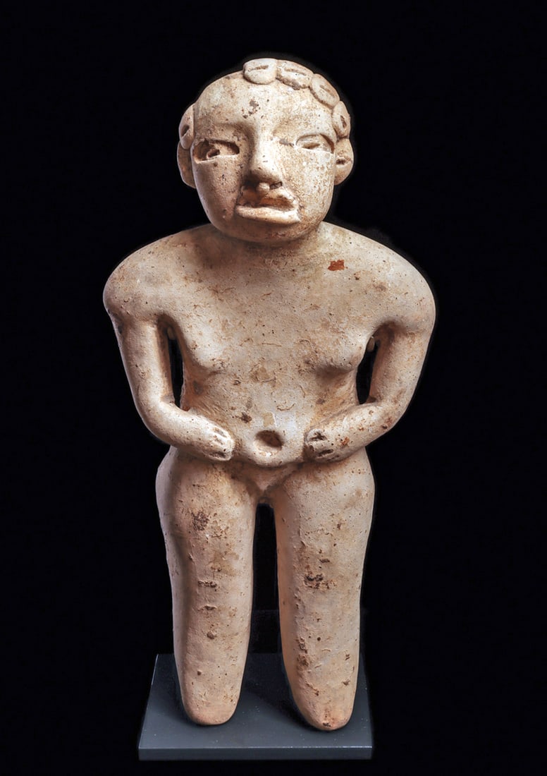 Olmecoid Standing Male: Cream slipped Usulutan Olmecoid figure of a standing well-proportioned male with prominent body and facial features. Simply adorned with a nose ring and a half head hairdo. Strong scattered mineral de