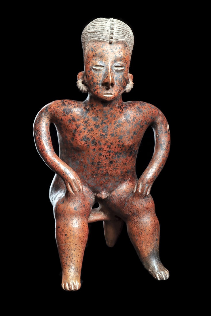San Sebastian Large Seated Male Figure: Large red-orange pottery male figure seated on a two-leg bench. Holding both hands on his knees. Nicely incised hairdo having a segmented rear braid and long tail between his shoulders. Overall strong