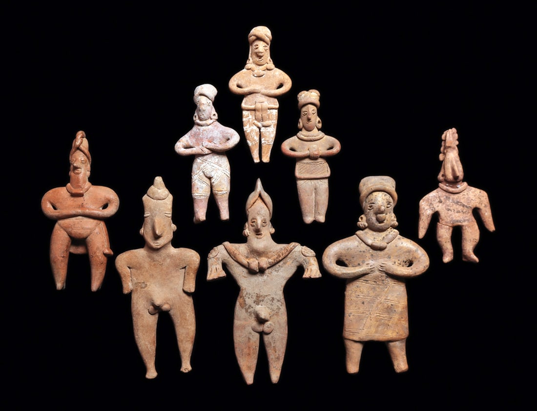 Group of Colima Standing Figures (8): Group of eight different buff color solid pottery standing figures, five are holding their hands to their stomachs, seven wearing necklaces. Two wear incised shorts with white pigment highlights. One