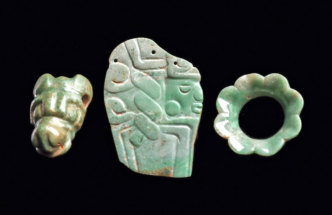 Maya Jade Animal Head Pendant, Floral Ear Spool & Plaqu: Three different carved jade examples, including a zoomorphic head, possibly a jaguar with perked ears. Two sets of biconical drilled suspension holes in his ear. Intact. Together with a carved blue-gr