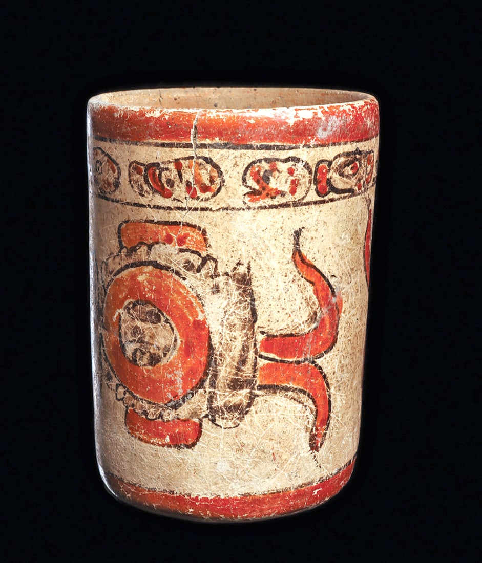 Maya Polychrome Decorated Cylinder Vase with Glyph: Polychrome decorated pottery cylinder vase. Decorated on both sides with a large glyph element. Upper glyph band. Scattered surface deposits. General wear to the painted decoration. Two minor tight ha