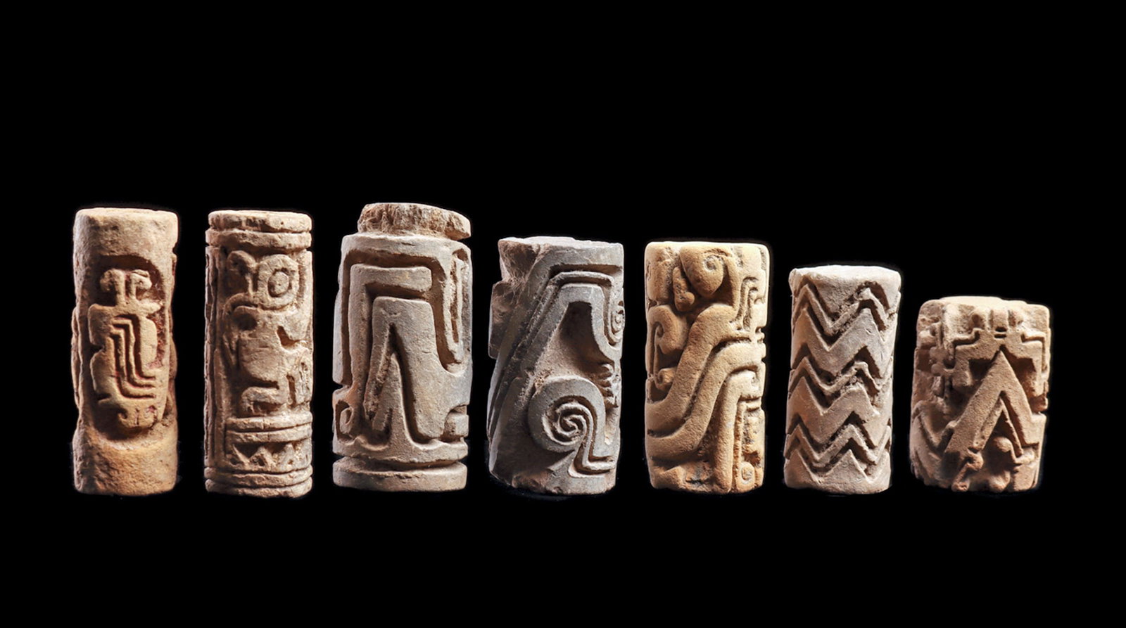 Ecuadorian Roller Seals (7): Group of seven different pottery roller seals, all having deeply carved designs. Including two with different animals, including a long beaked bird and a lizard. The remaining five are all carved with