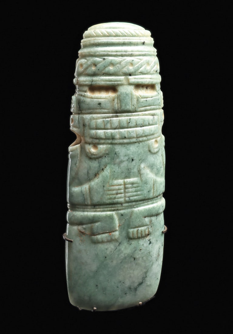 Costa Rican Jade Axe God Pendant: Carved medium blue-green jade axe god celt, having elaborate and beautifully carved details: wide toothy mouth, recessed eyes, incised detailed cheeks and nose, relief carved twist type head band with