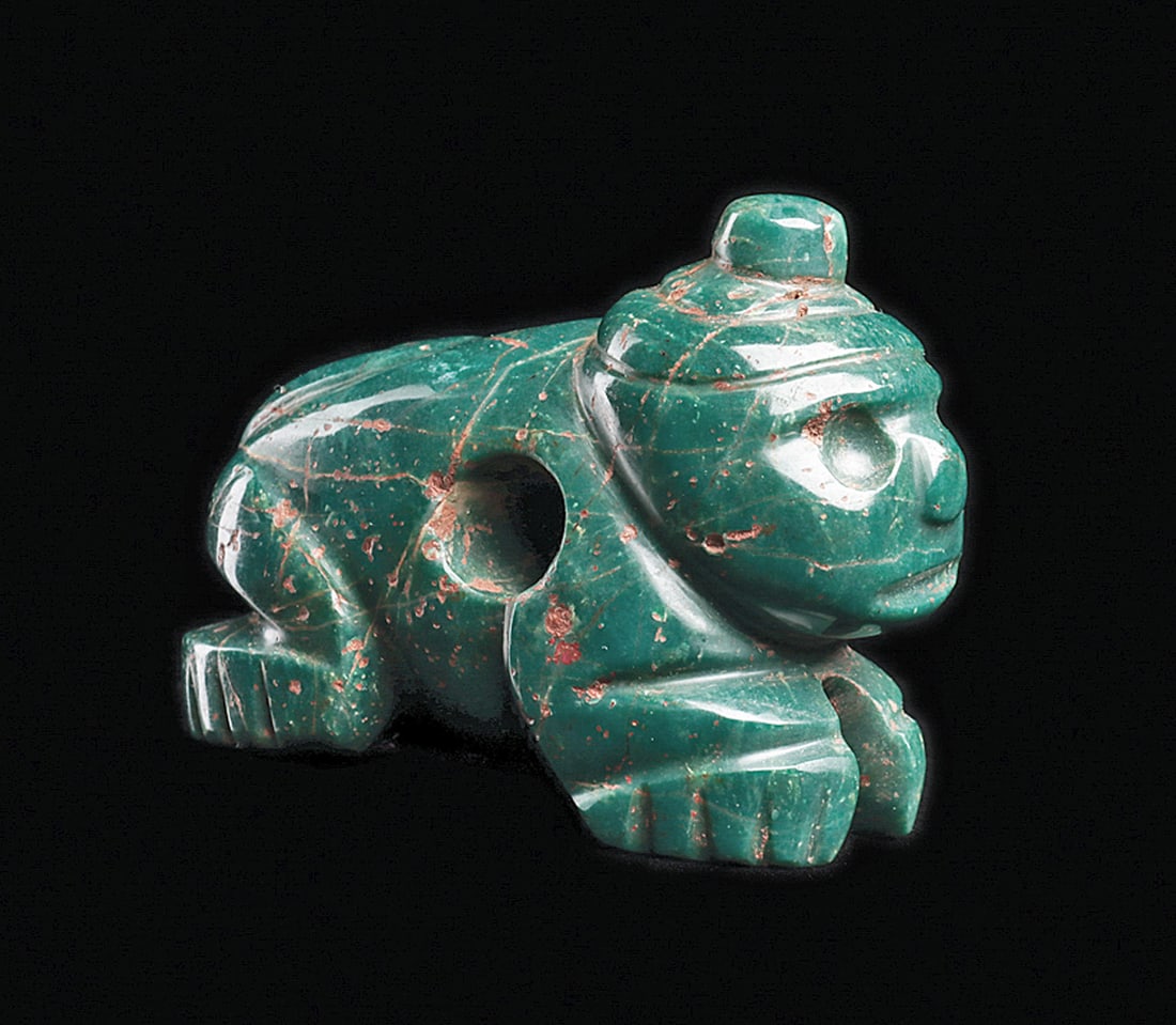 Costa Rican Blue Jade Crouching Monkey Pendant: Fine carved blue-green jade crouching monkey deity pendant, depicting wearing a cap with a center disc finial, drilled round eyes and a long tail curled over his back. Large biconical drilled suspensi