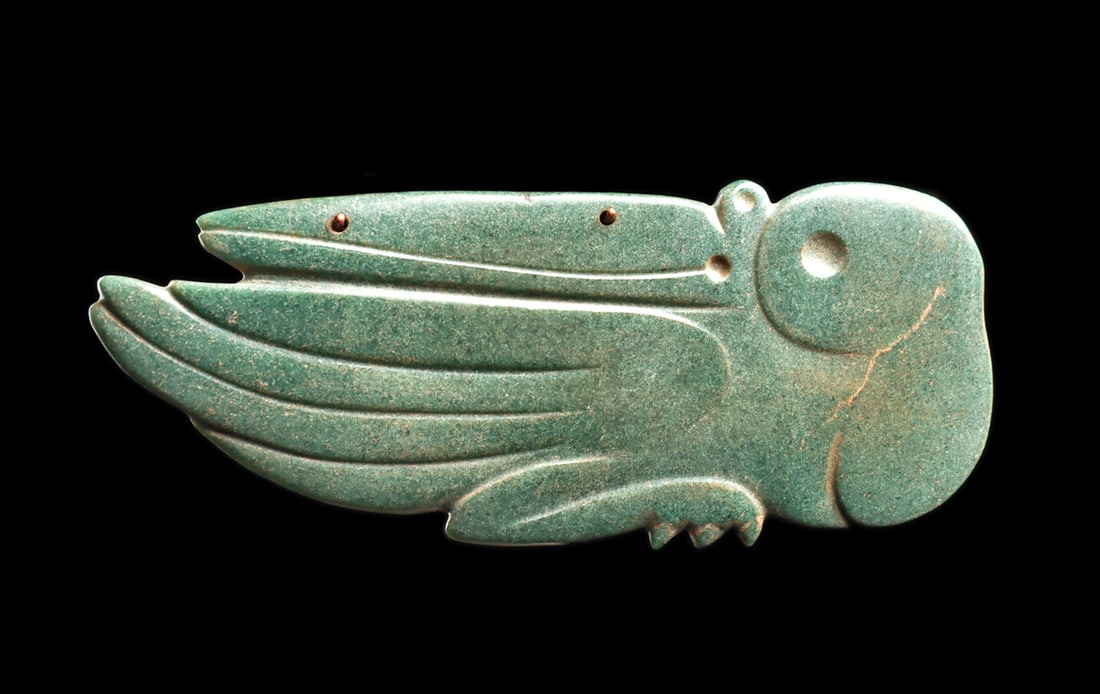 Costa Rican Jade Pelican Pendant: Fine carved blue-green jade large avian pendant, depicting a seabird, probably a pelican, with his head turned backwards, his long beak resting on his back and long upturned wing feathers. Two small b
