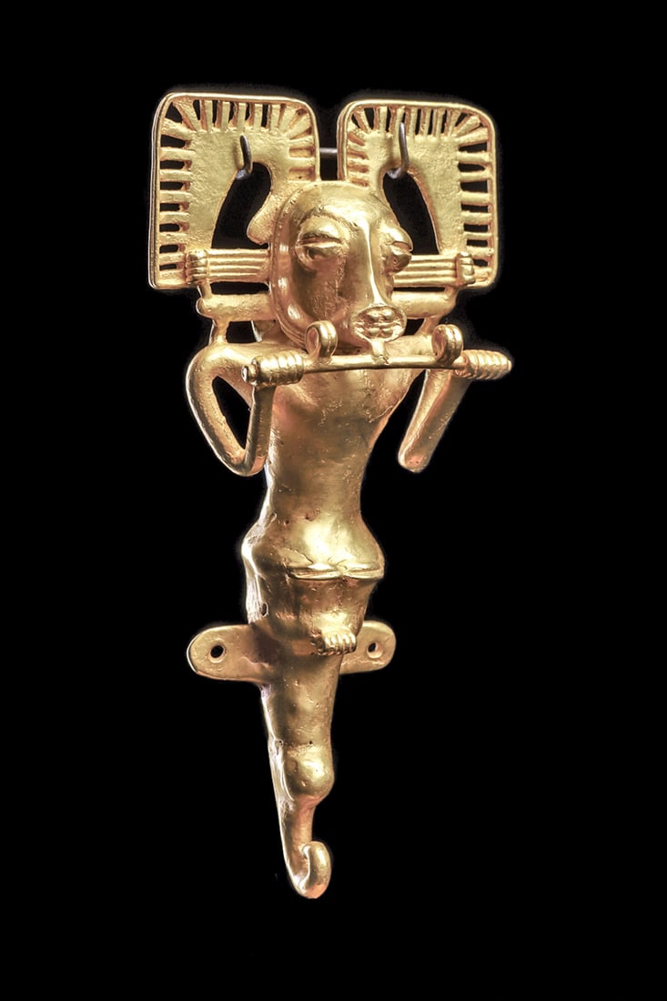 International Gold Zoomorphic Pendant: Fine and heavy gold pendant depicting a mythological zoomorph having a stylized human body and holding a long bar to his chin with both hands. A zoomorphic stylized head, with an oval toothy mouth and