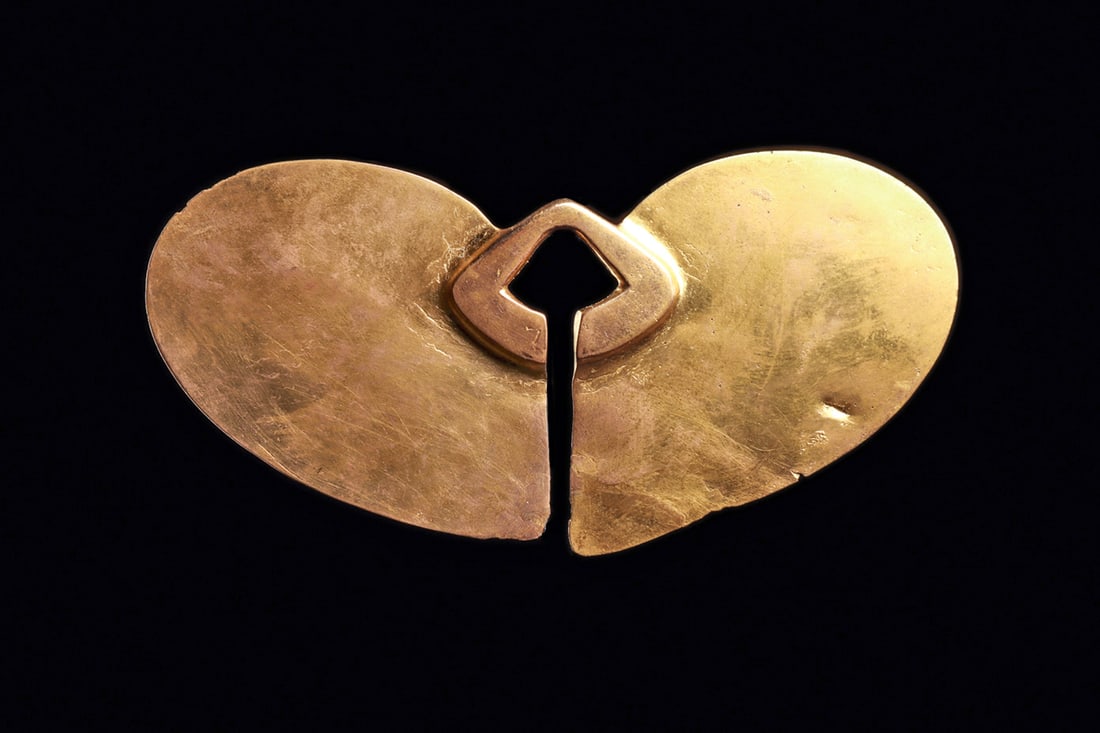 Tairona Gold Broad Winged Nose Ornament: Large cast and hammered gold nose ornament having a central angular relief ring fitting and large butterfly shaped twin opposing wings. Some general light surface wear and a few very minor bits of edg
