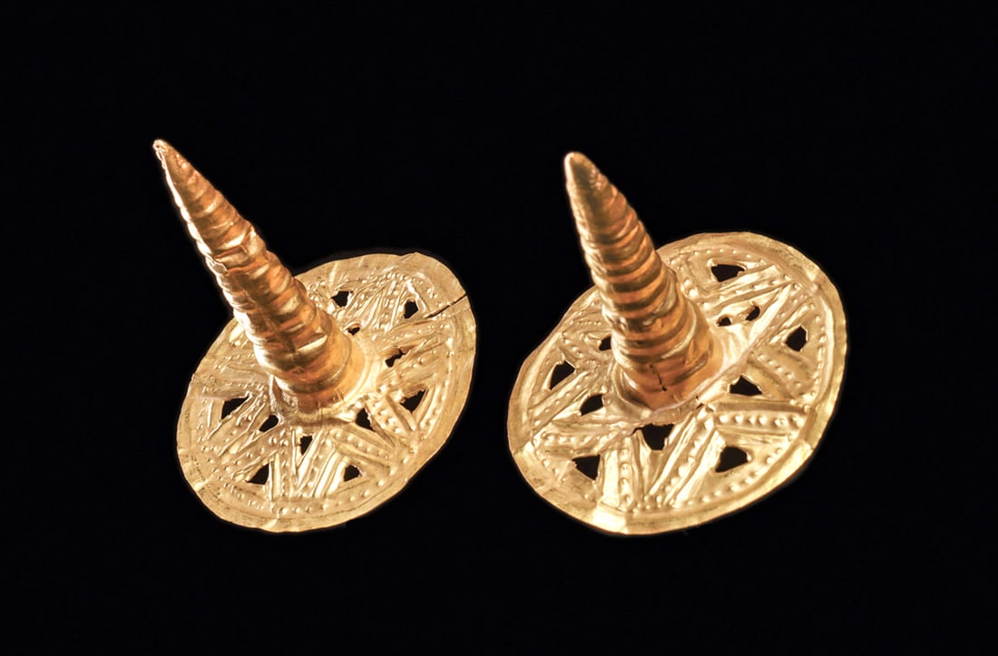 Ecuadorian Gold Witches Hat Pendants: Matched pair of sheet gold "witches hats" ear ornaments each having a lower round sheet gold disc decorated with a seven pointed star with openwork decoration. Central tall conical tapered element. So