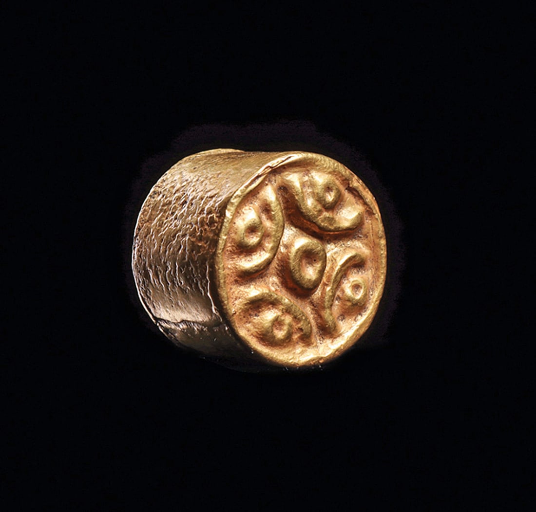 Colombian Gold Labret: Gold drum shape labret, capped on both ends, one end decorated with a relief design of five circular elements with linear arches separating the circles. A minor dent on the outer edge, otherwise intac