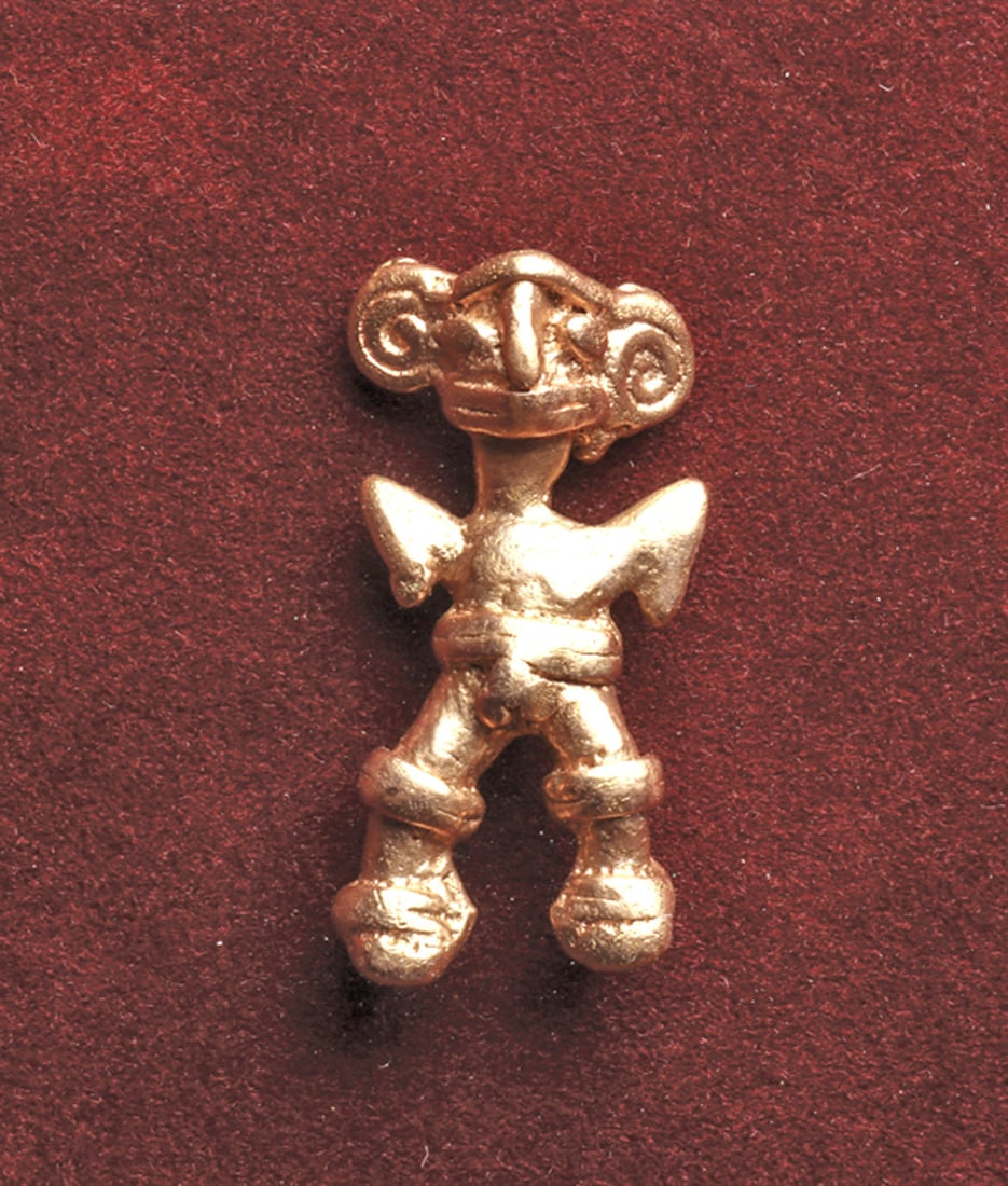 Veraguas Anthropomorphic Gold Pendant: Cast gold figural pendant depicting a standing figure having large spiral ears, arms held in an upright position, bent at the elbows. Integral suspension loop on the back of his head. Intact, exc. con