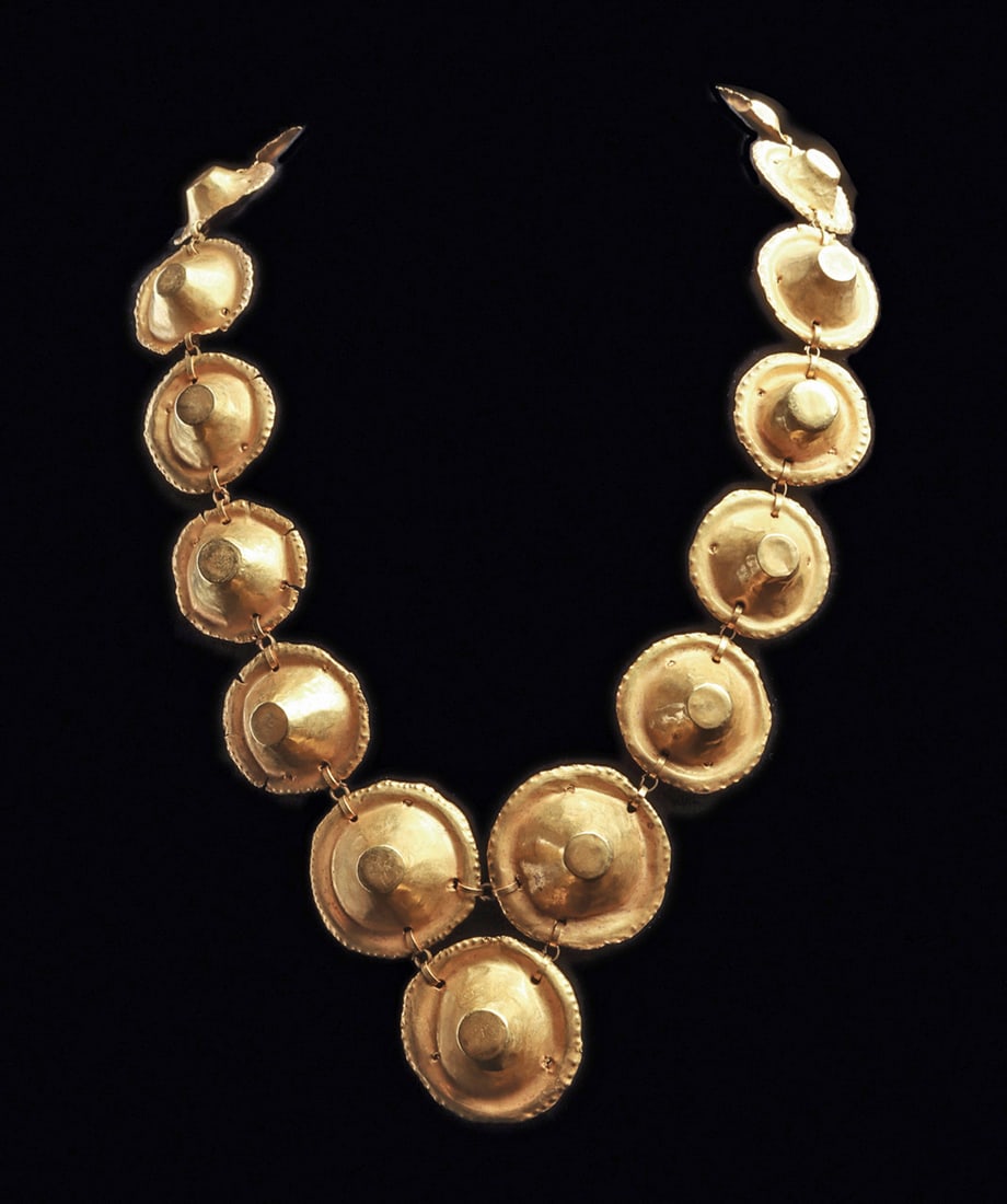 Sinu Gold "Hat" Necklace: Single strand gold necklace composed of fifteen gold conical hat type elements with wide beaded brims and flat tops. Perforated suspension holes in their brims, connected to one another with flat gold