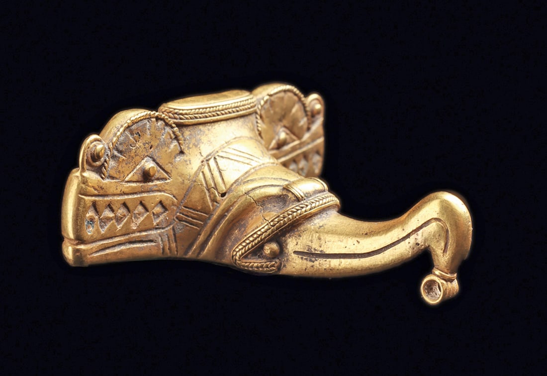 Tairona Gold Composite Animal Pendant: Fine gold composite avian/animal Pendant depicted with a central projecting bird head having a long tapered hook beak with an integral attachment ring at the tip. Faux braided borders on the birds bea