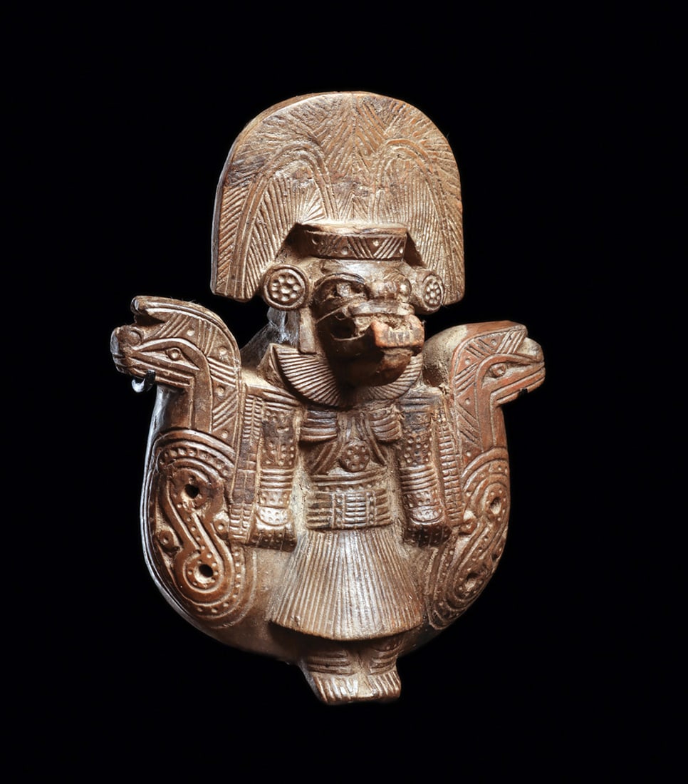 Tairona Figural Ocarina / Whistle: Molded chocolate ware pottery figural ocarina / whistle, depicting a deity figure in the center flaked by a mythological serpent on both sides. Deity is depicted with an extended lower jaw with fangs,