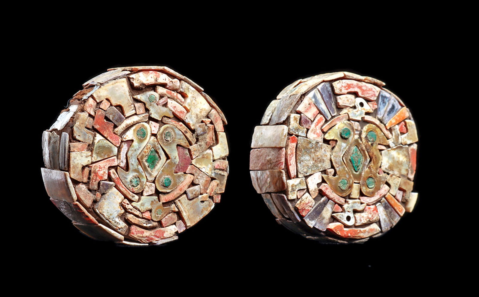 Chimu Mosaic Decorated Ear Ornaments: Matched pair of ear ornaments having a solid wood core, inlaid on the face and edges with cut mosaic shell pieces of various colors, depicting two double headed birds in the center with a central diam