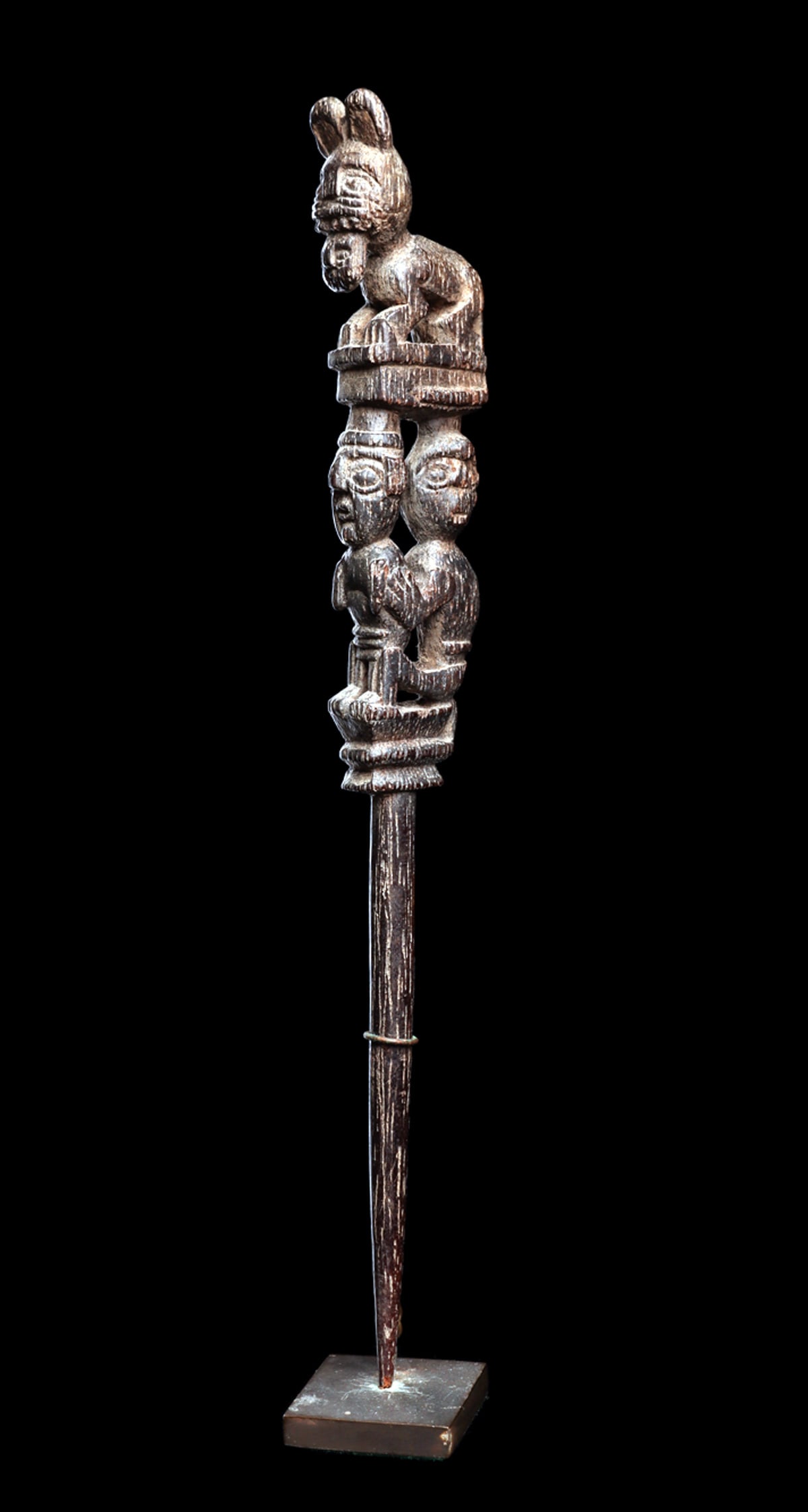 Inca Figural Wood Dipper: Hardwood poporo dipper having an elaborately carved finial depicting a jaguar holding a human head in his mouth, above a standing human figure being held by another human figure and a seated behind th