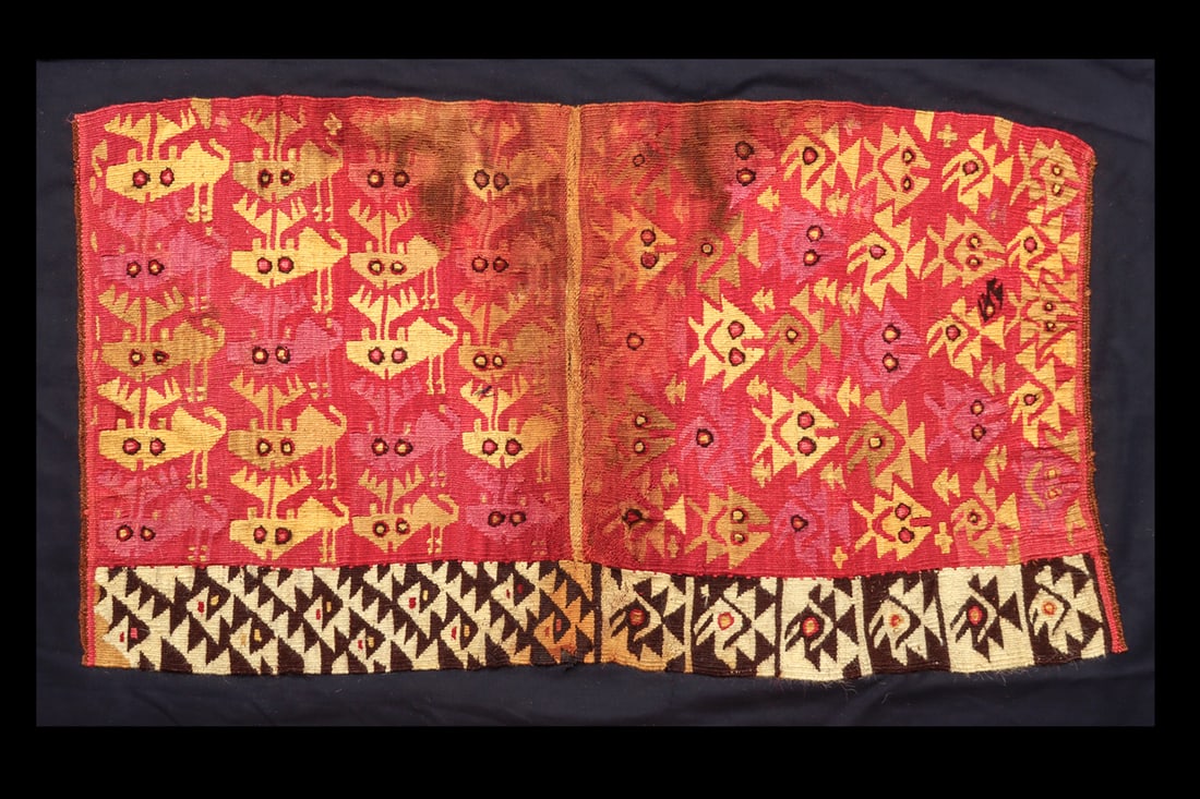 Chancay Deer Fish & Bird Textile Panel: Rectangular multicolor panel section originally from a shirt. The left section has an overall decoration depicting a school of fish alternating with spread winged birds. The right section is decorated