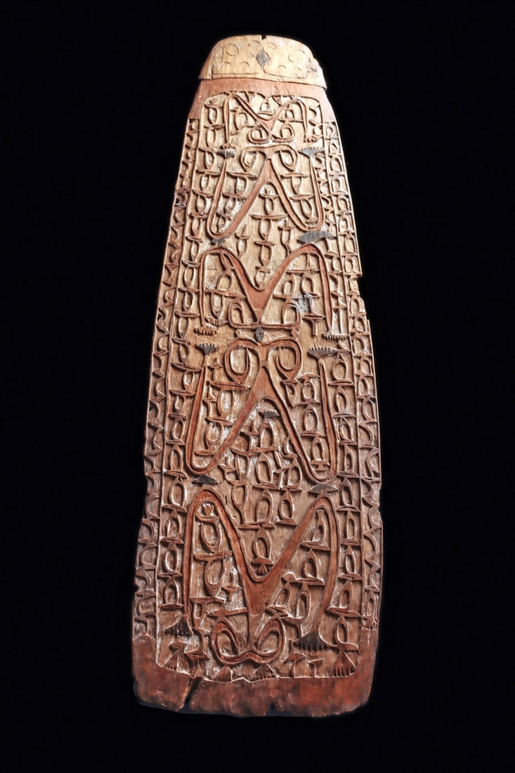 Asmat Shield: Fine well carved large shield, stylized head of a ray fish forms top, and the main body of the shield is covered with well carved relief designs, five flying fox motifs in expanding size along the cen