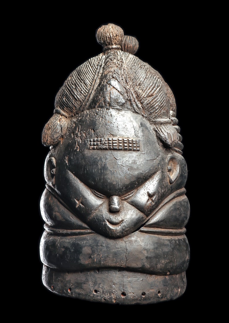 Mende "Bundu" Helmet Mask: Helmet mask of the Mende, worn by the all-female Bundu (Sande) Society, carved with an elegant coiffure composed of four braided sections, surmounted by two small spherical hair buns. The broad,
