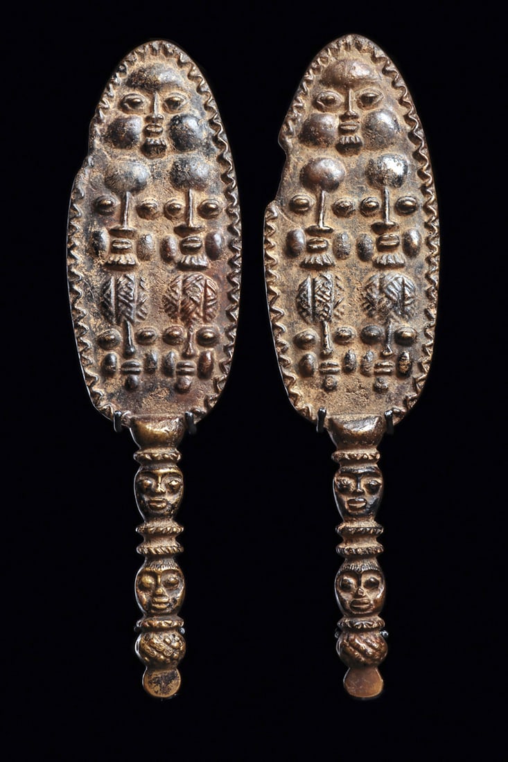 Pair of Yoruba Bronze Clappers: Rare, small copper alloy matching musical clappers or fans, the ovoid paddles with relief faces, some of the heads with beards, and patterned headdresses. Back of the finials unadorned. The handle in