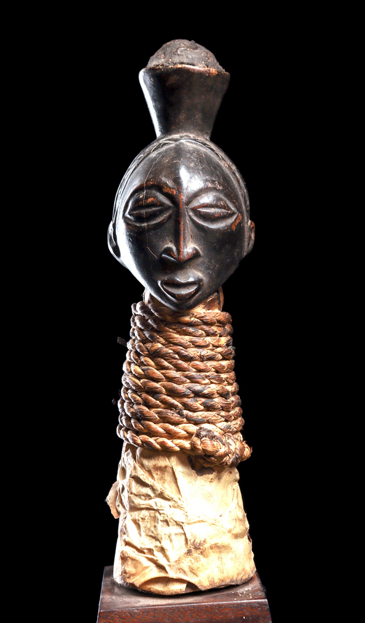 Hemba Janus Power Figure: "Carved wood figure with opposing heads, having a male and female faces, representing opposing spirits in nature, with conical headdress above holding compounded organic material, possibly animal bone