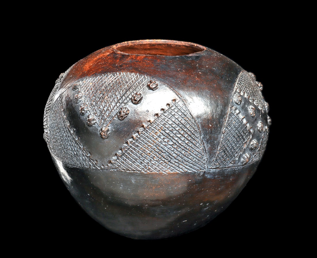Zulu Beer Vessel: Small Zulu terracotta vessel "ukhamba", traditionally used for serving sorghum beer, made by a potter of the Magwa za family. The rounded body rises from a flat tapered base and is finished with a