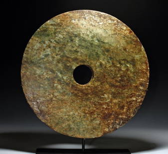 Large Chinese Jade Bi-Disc, Liangzhu Culture: China, Neolithic Period, Liangzhu Culture, ca. 3400 - 2250 BCE. A very large carved Chinese jade bi-disc, with a wonderful mix of green, brown, yellow, and white in the jade. Discs like this were