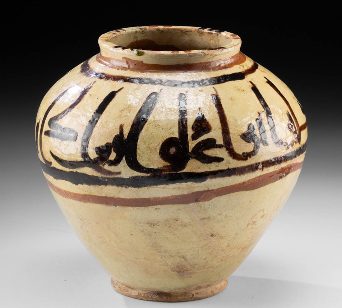 12th C. Persian Rayy Vessel w/ Bold Kufic Inscription: Central Asia, Persia (Iran), Rayy region, ca. 12th to 13th century CE. A ceramic vessel is decorated with a sweeping band of bold black-brown Kufic calligraphy encircling the shoulder, set against a b