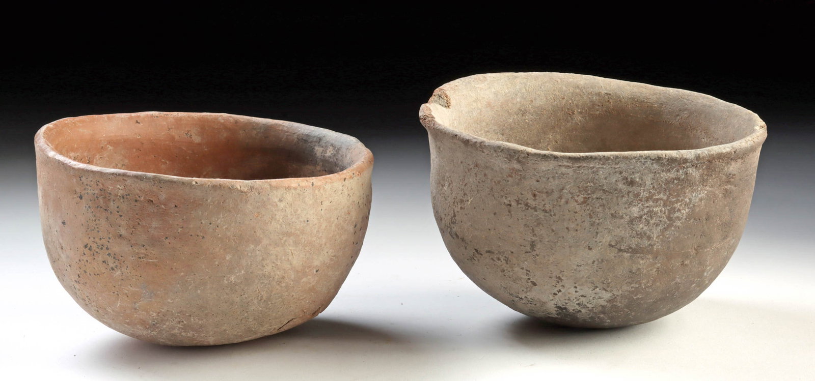 Pair of Levantine Bronze Age Pottery Bowls: Near East, Levantine region, Bronze Age, ca. 3000 to 1200 BCE. A quietly compelling pair of Levantine Bronze Age pottery bowls, each formed with broad, open profiles and gently rounded walls that sett