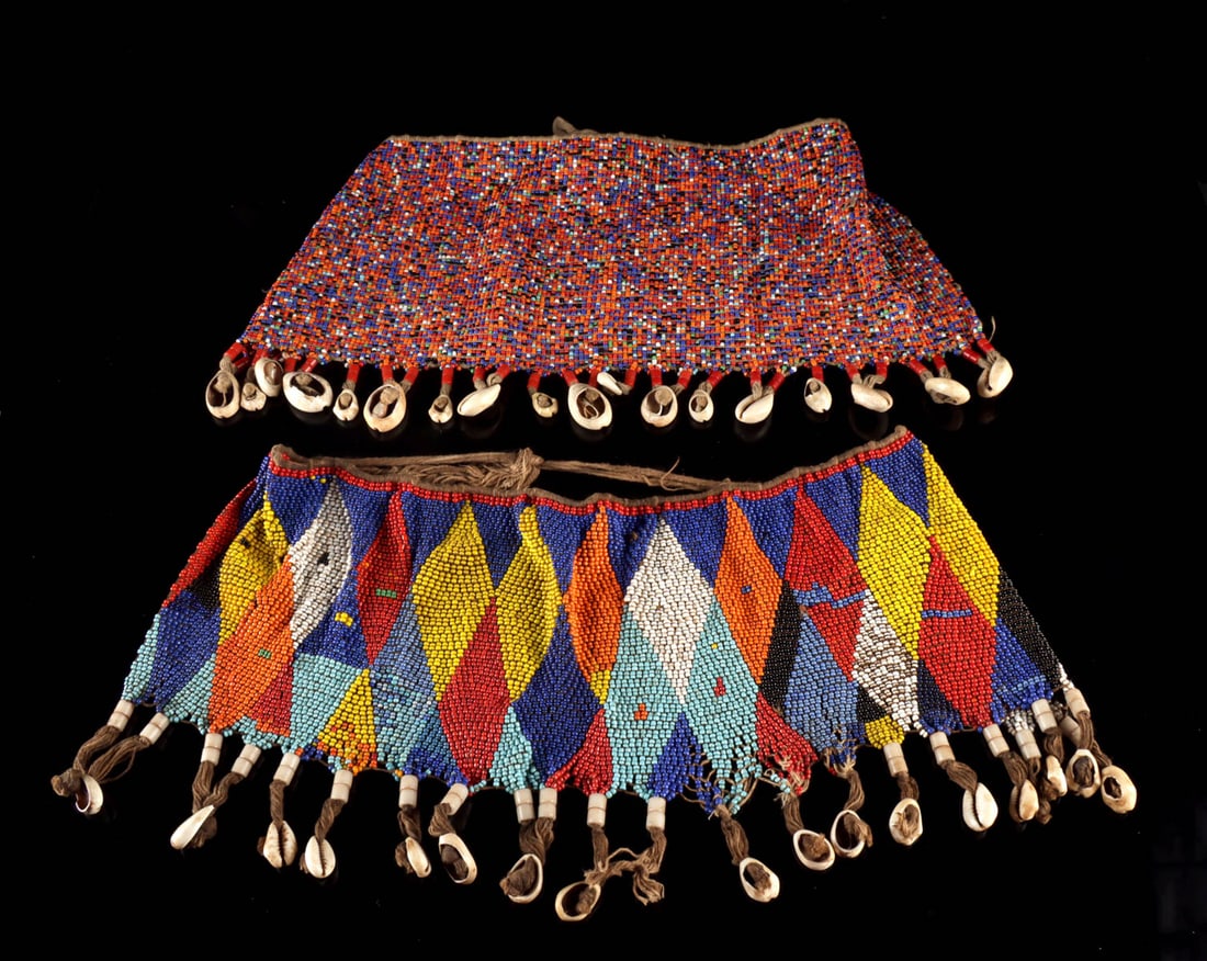 Cameroon Kirdi Beaded & Cowrie Shell Modesty Aprons: West Africa, Cameroon, Bana Guili (Kirdi) peoples, ca. early to mid-20th century CE. A pair of beaded modesty aprons (dibul kouana), constructed from multicolored glass seed beads strung on cotton fib