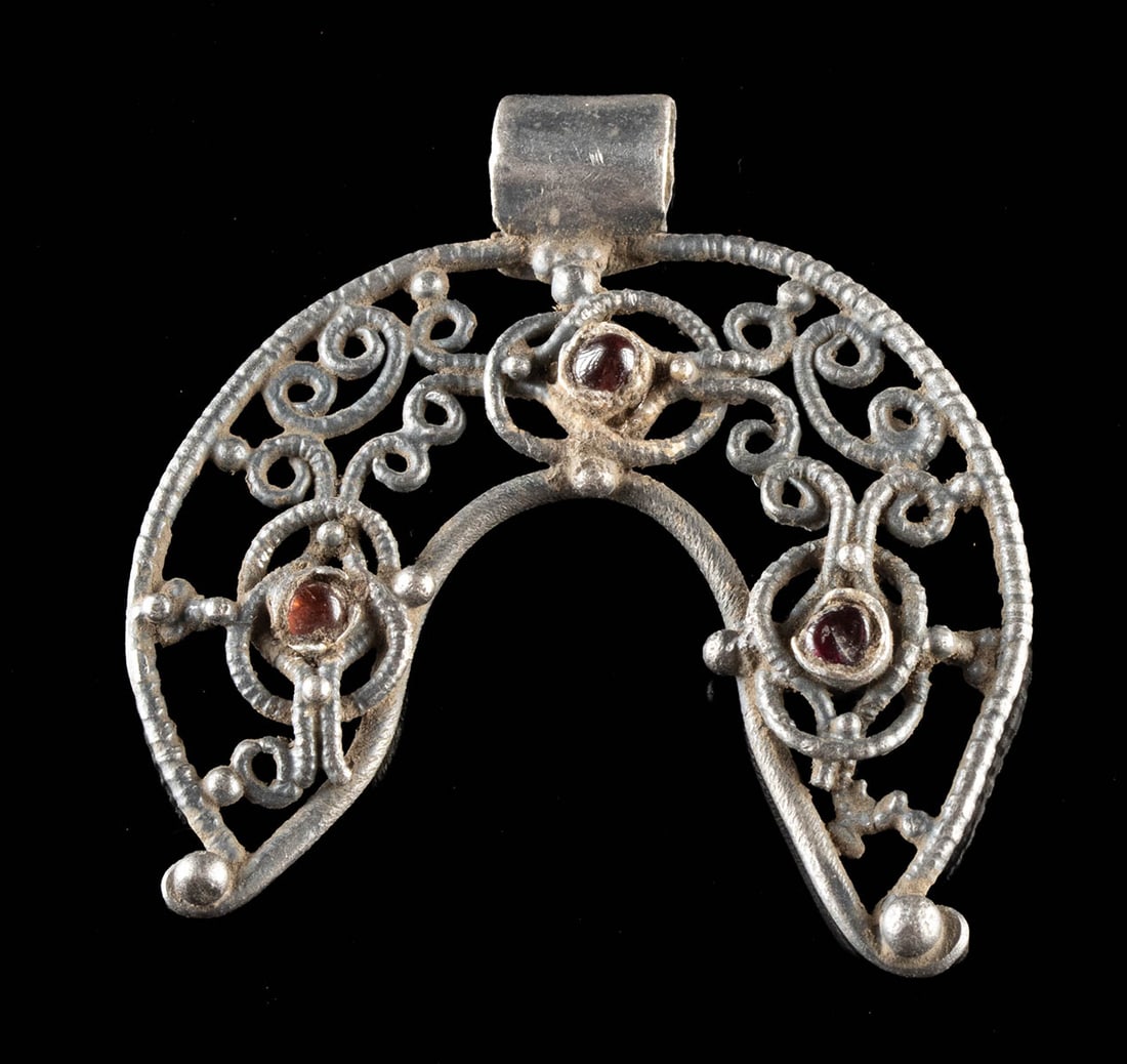 Rare Viking Silver Openwork Pendant with Amethysts: Northern Europe, Scandinavia, Viking culture, ca. 9th to 11th century CE. An opulent Viking silver lunula pendant, distinguished by its elaborate openwork construction and the luminous presence of thr